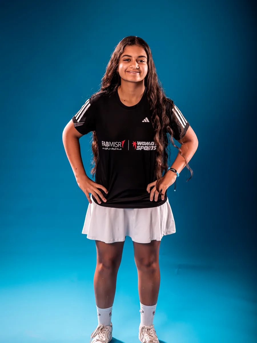 رياضية شابة بقميص Women in Sports، يداها على خصرها